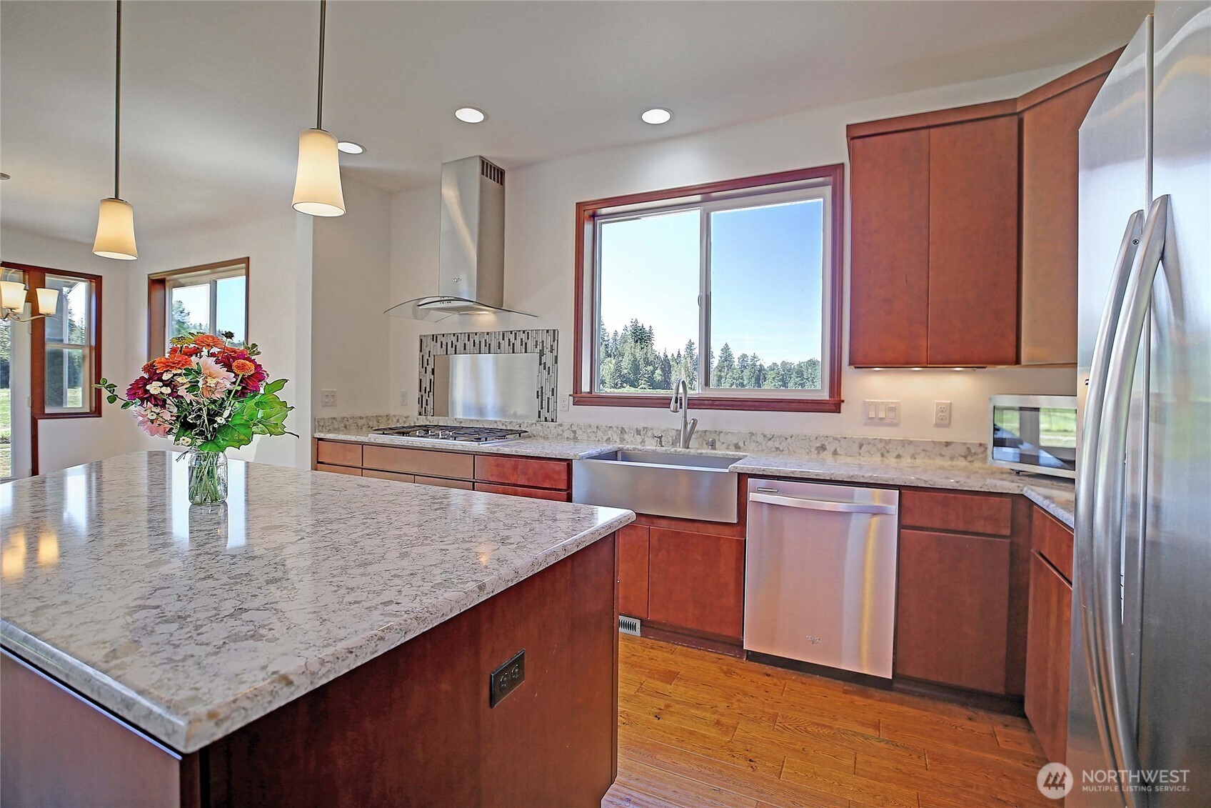 12631 State Rte 530 Northeast Arlington, WA 98223 - Photo 15 of 40 a kitchen with stainless steel appliances granite countertop a kitchen island a stove a sink dishwasher and cabinets with wooden floor