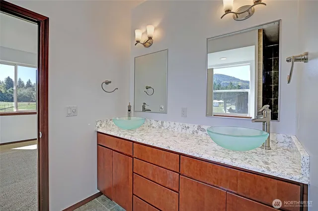 a bathroom with a granite countertop sink and a large mirror
