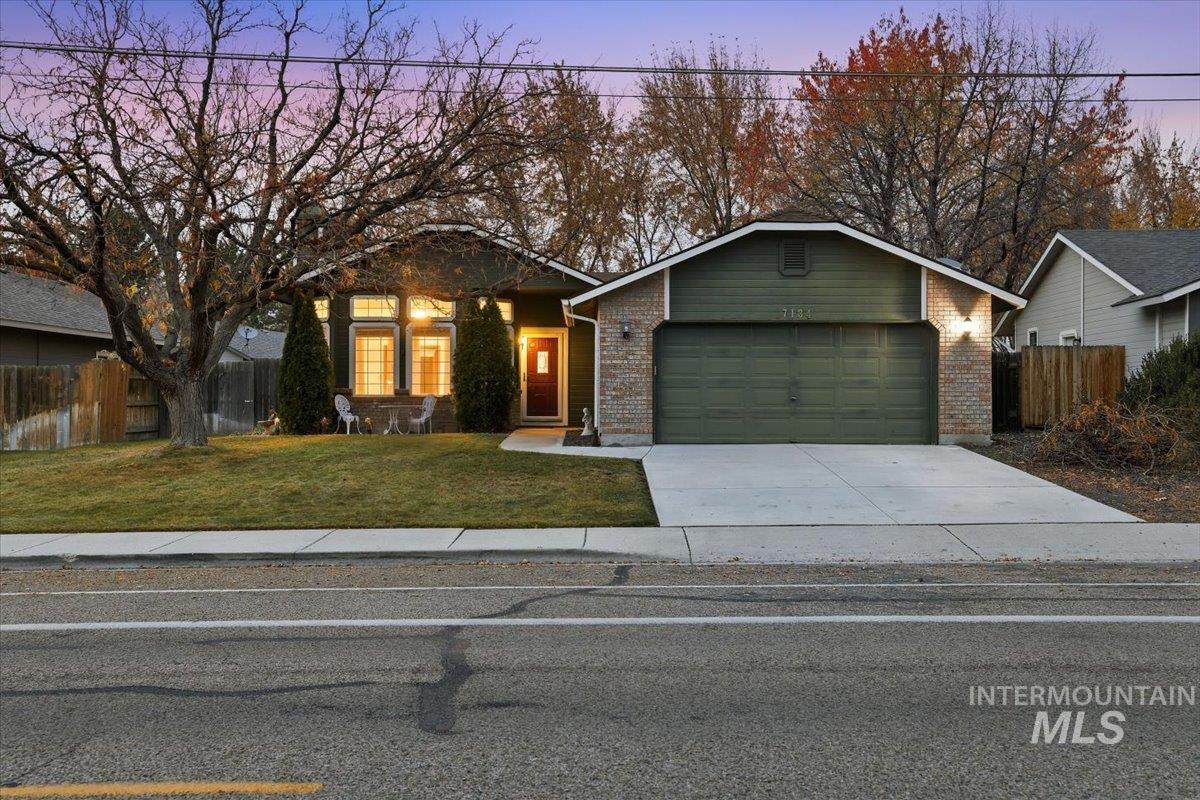 7134 West Amity Road Boise, ID 83709 - Photo 1 of 20 View of front of home featuring concrete driveway, brick siding, and an attached garage
