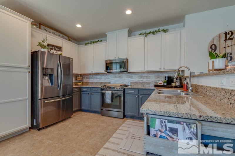 9150 Andraste Way Reno, NV 89506 - Photo 7 of 23 a kitchen with granite countertop a refrigerator and a sink