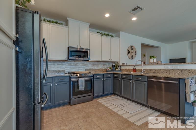 9150 Andraste Way Reno, NV 89506 - Photo 8 of 23 a kitchen with stainless steel appliances granite countertop a stove a sink and a refrigerator