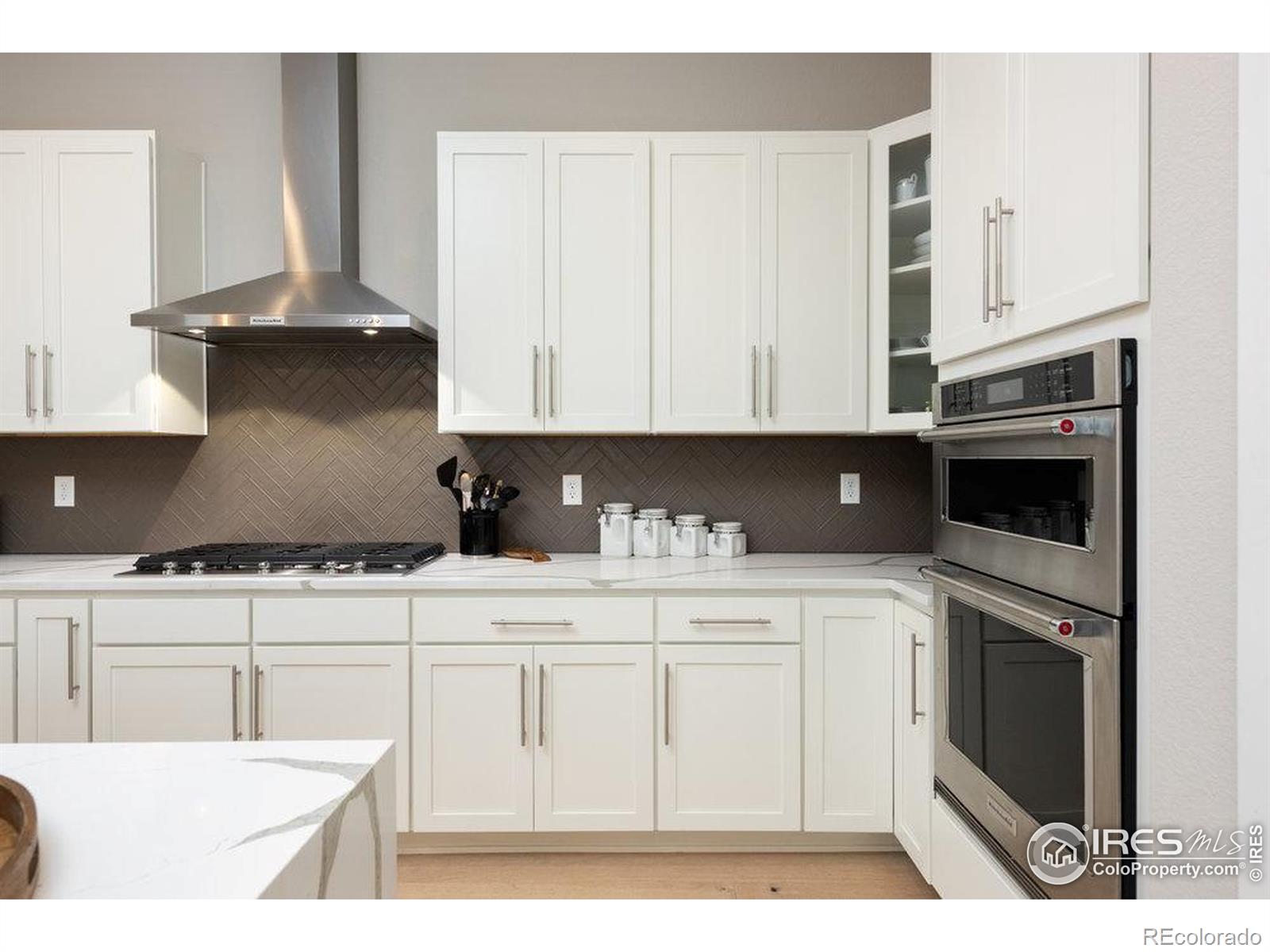 730 Promenade Drive Superior, CO 80027 - Photo 11 of 50 a kitchen with stainless steel appliances granite countertop a stove a sink and white cabinets