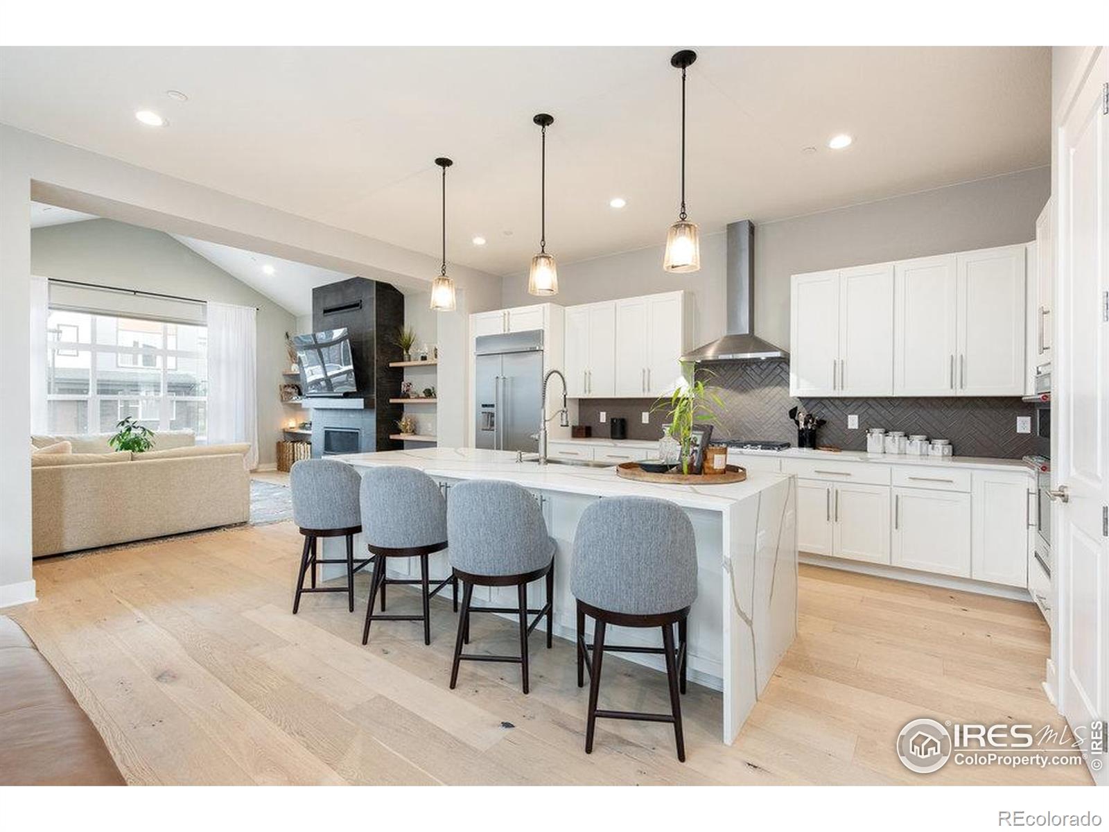 730 Promenade Drive Superior, CO 80027 - Photo 13 of 50 a open kitchen with stainless steel appliances granite countertop a stove a sink dishwasher white cabinets and a dining table with wooden floor