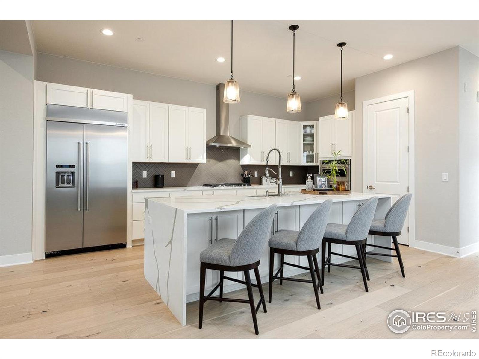 730 Promenade Drive Superior, CO 80027 - Photo 8 of 50 a kitchen with stainless steel appliances kitchen island granite countertop a table chairs refrigerator and microwave