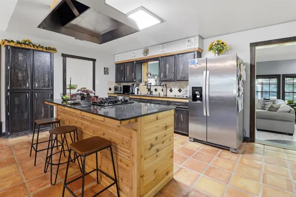 a kitchen with stainless steel appliances granite countertop a sink a stove and refrigerator