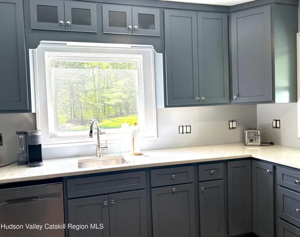 a kitchen with granite countertop cabinets stainless steel appliances and wooden cabinets