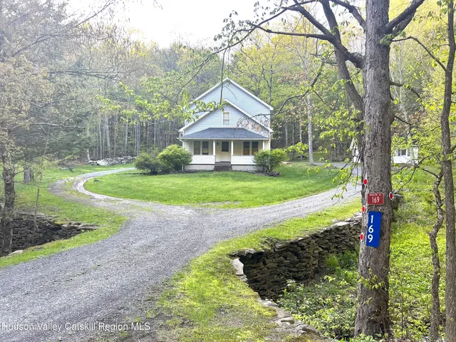 a front view of a house with yard and green space