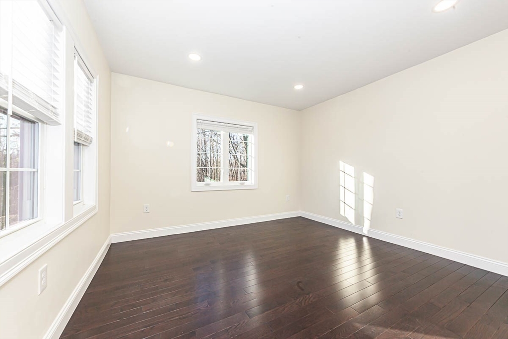 48 Caldwell Road, Unit 48 Waltham, MA 02453 - Photo 11 of 38 an empty room with wooden floor and windows