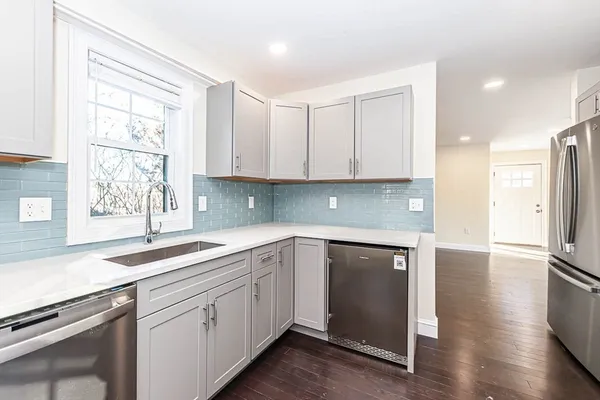 a kitchen with a sink cabinets stainless steel appliances and a window