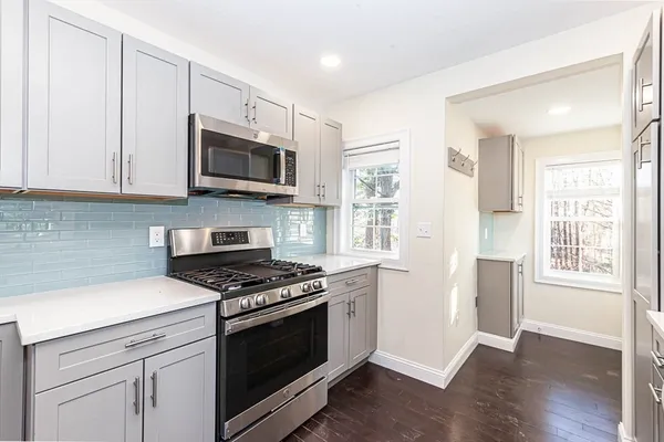 a kitchen with stainless steel appliances white cabinets and a stove top oven