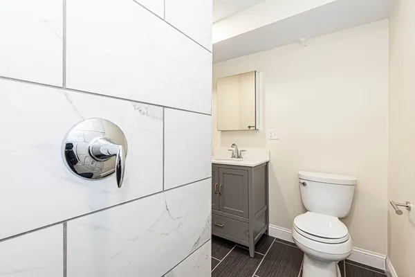 a bathroom with a toilet a sink and mirror