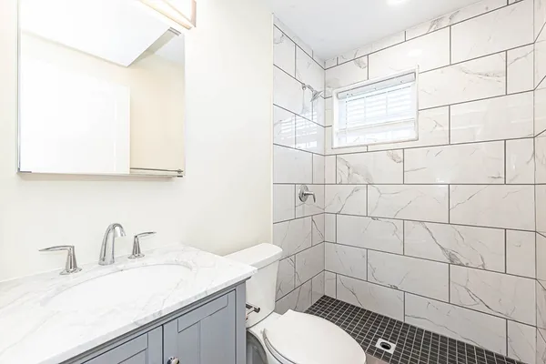 a bathroom with a sink a toilet and shower