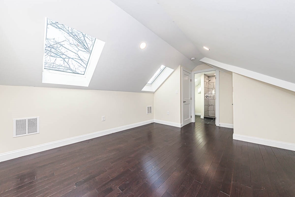 48 Caldwell Road, Unit 48 Waltham, MA 02453 - Photo 31 of 38 an empty room with wooden floor and windows