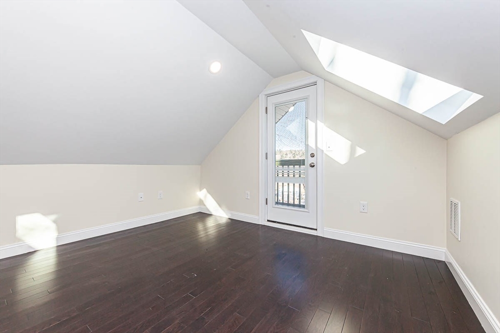 48 Caldwell Road, Unit 48 Waltham, MA 02453 - Photo 32 of 38 a view of an empty room with wooden floor and a window