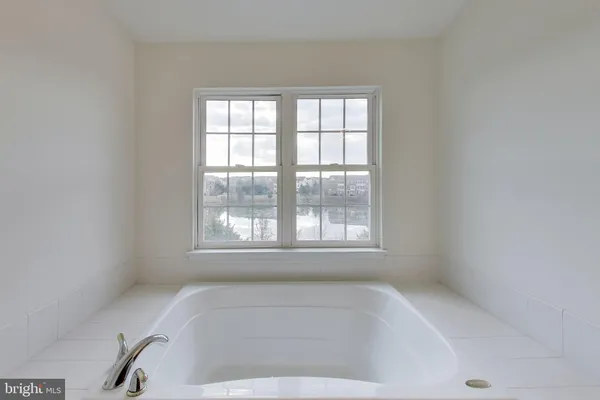 a white bath tub sitting in a bathroom next to a window