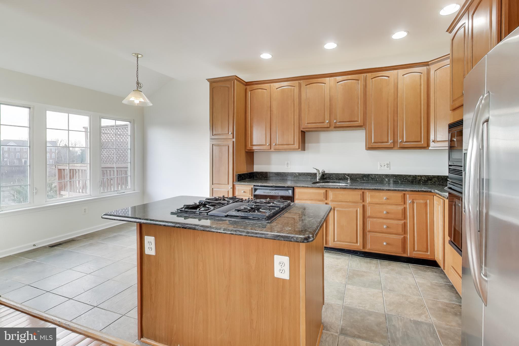 42759 Locklear Terrace Chantilly, VA 20152 - Photo 6 of 38 a kitchen with stainless steel appliances granite countertop a sink a stove and a refrigerator
