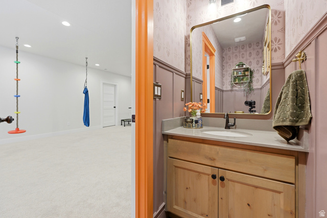 4331 West 475 South West Point, UT 84015 - Photo 29 of 46 Powder room featuring a single vanity with wood-finish cabinetry, a white basin, and a wall-mounted mirror