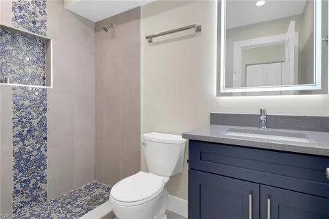a bathroom with a granite countertop sink toilet and shower