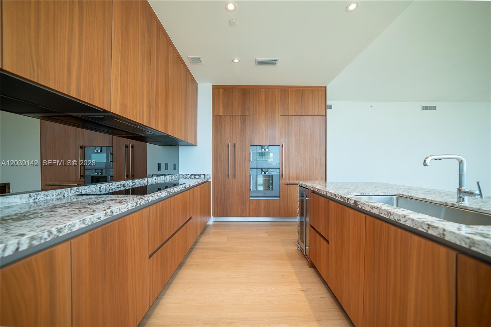 175 Southeast 25th Road, Unit 702 Miami, FL 33129 - Photo 17 of 30 a large kitchen with granite countertop a sink and cabinets