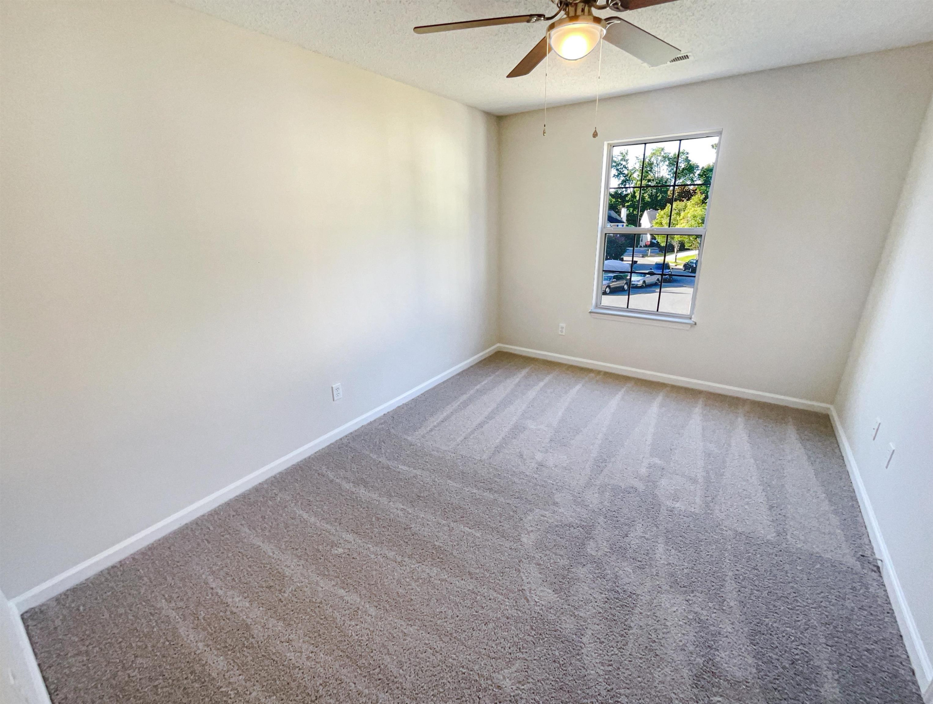 7416 Wisconsin Court Raleigh, NC 27615 - Photo 12 of 17 an empty room with windows and chandelier fan