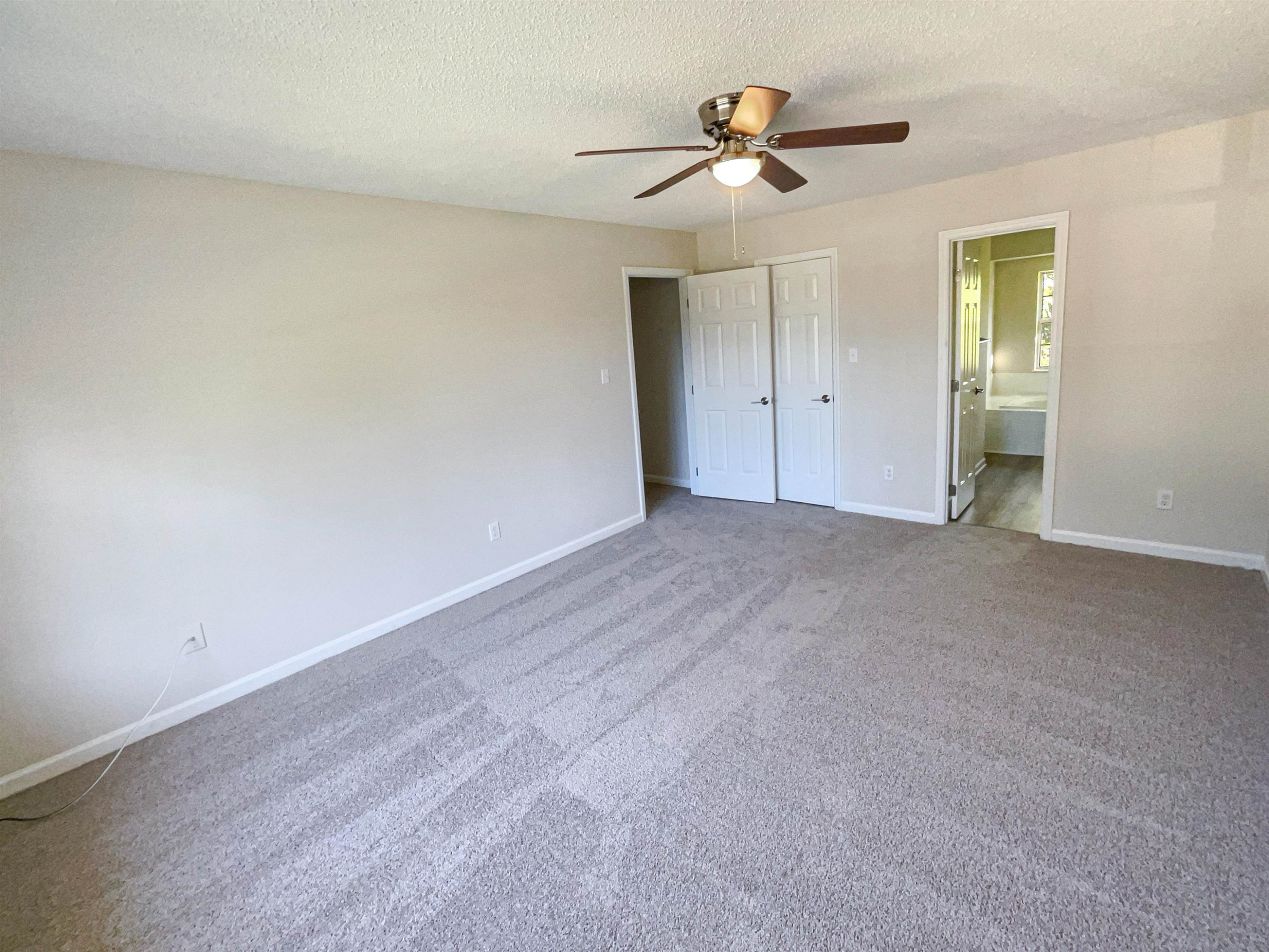 7416 Wisconsin Court Raleigh, NC 27615 - Photo 14 of 17 an empty room with ceiling fan and window