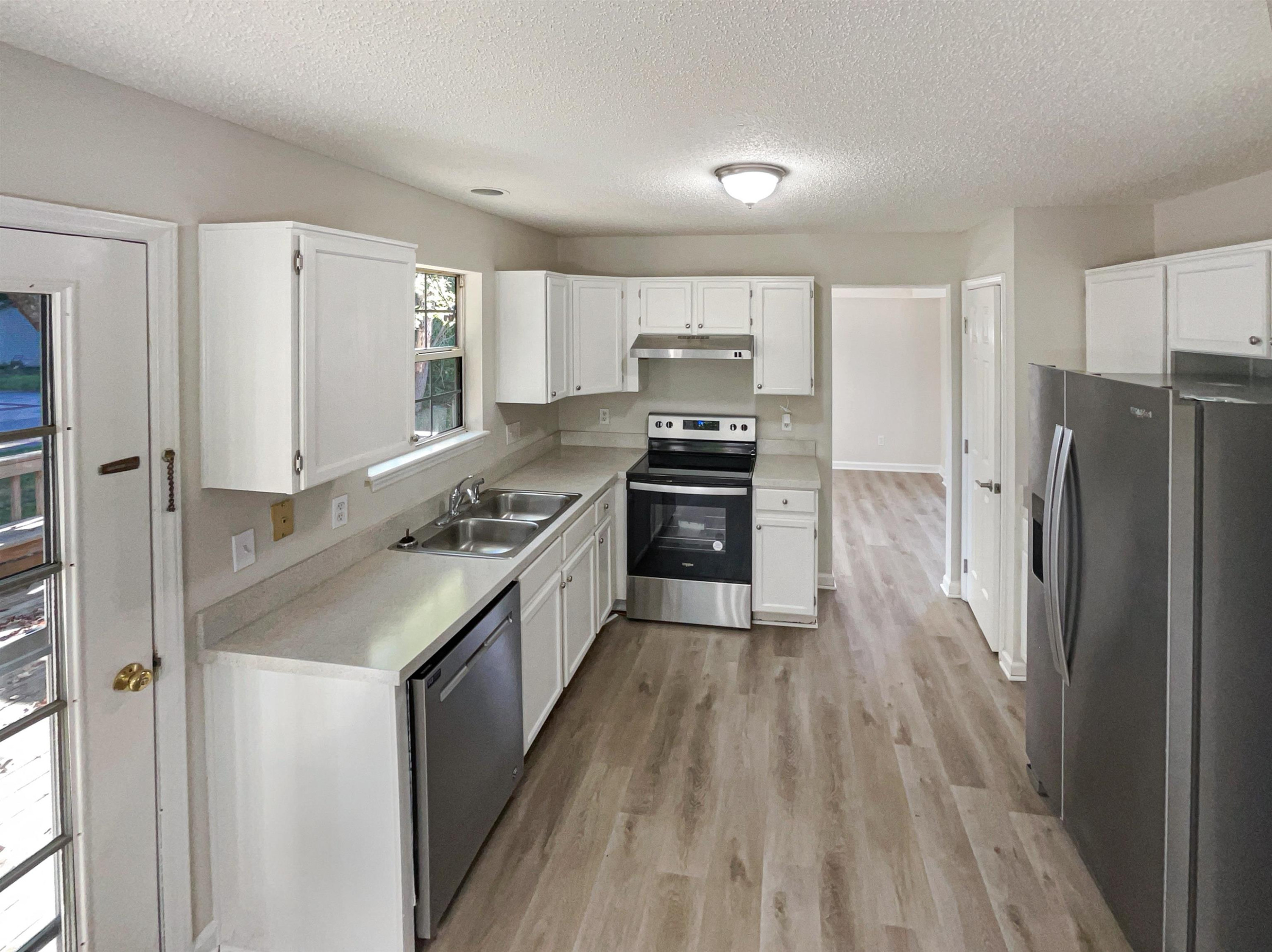 7416 Wisconsin Court Raleigh, NC 27615 - Photo 6 of 17 a kitchen with stainless steel appliances granite countertop a refrigerator a stove and a wooden floors