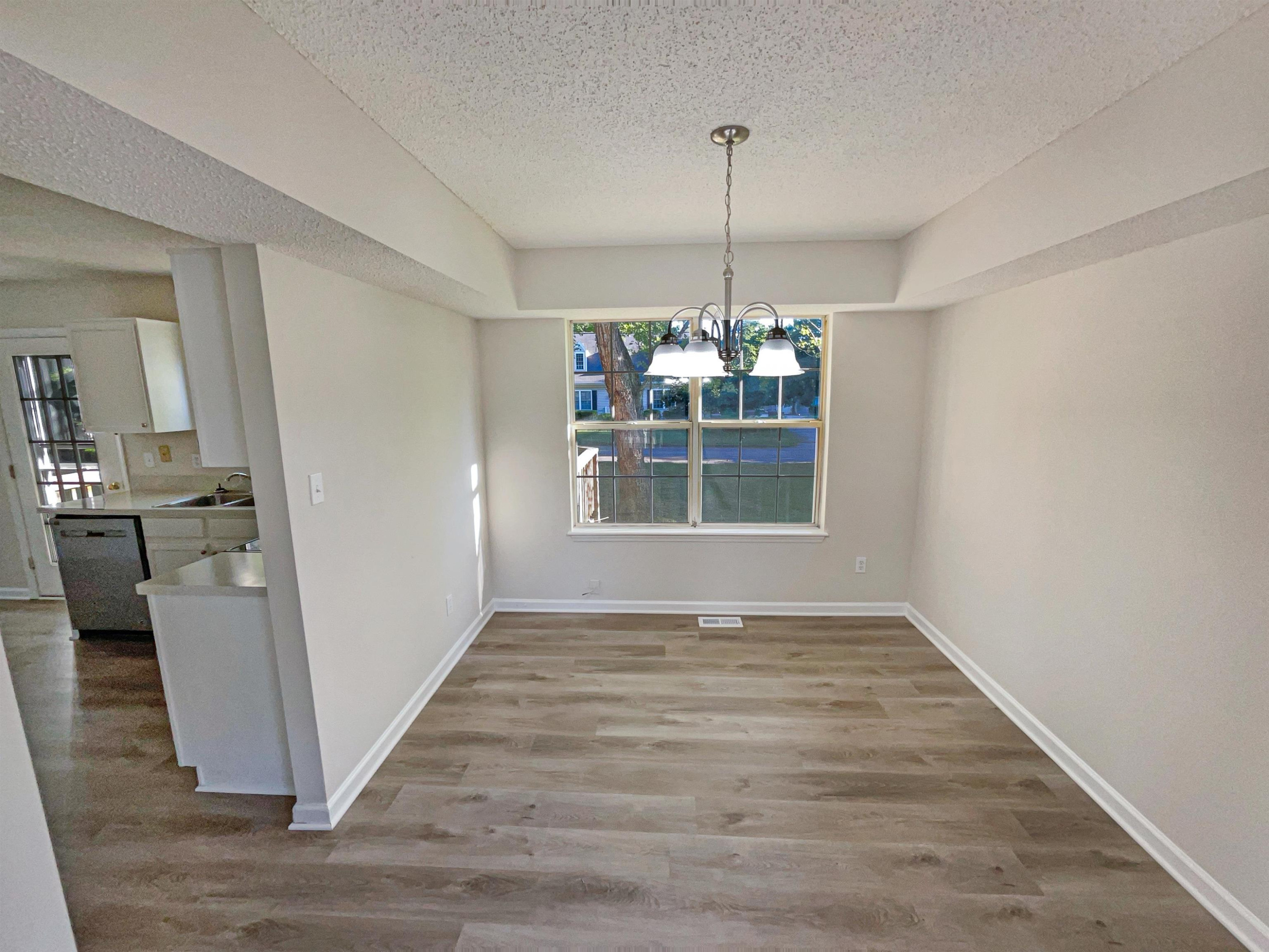 7416 Wisconsin Court Raleigh, NC 27615 - Photo 8 of 17 a view of a room with wooden floor kitchen and window