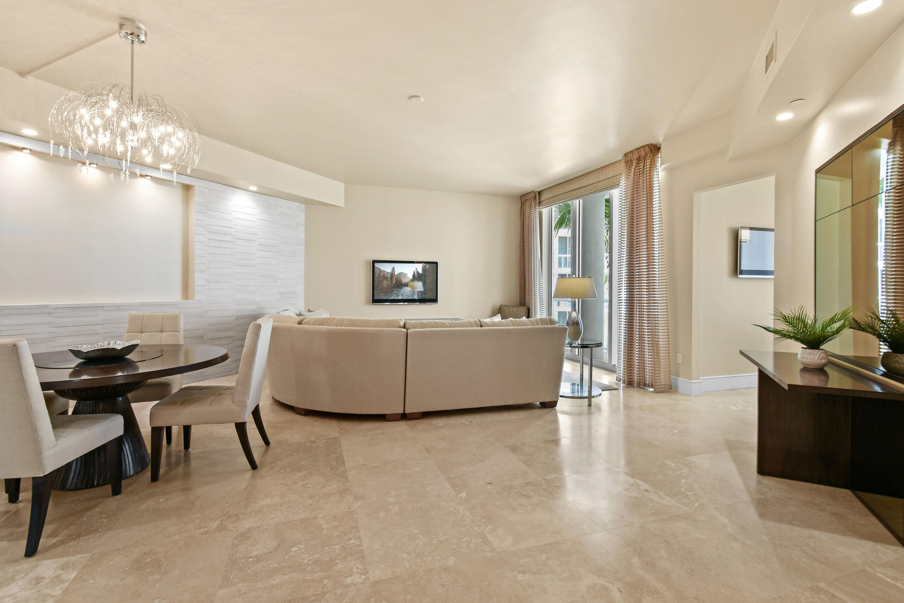 4600 North Ocean Drive, Unit 406 Singer Island, FL 33404 - Photo 4 of 106 a living room with furniture a chandelier and a flat screen tv