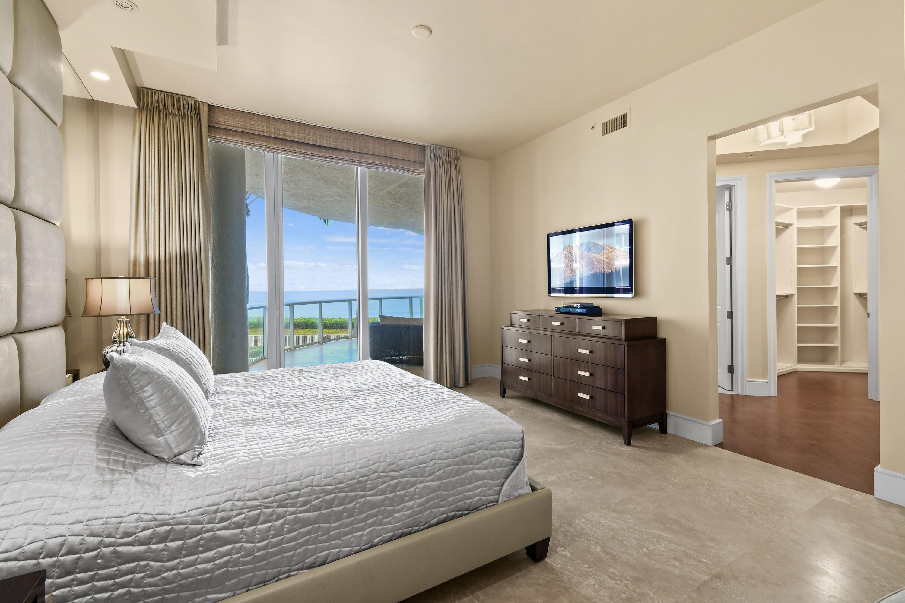 4600 North Ocean Drive, Unit 406 Singer Island, FL 33404 - Photo 41 of 106 a bedroom with a large bed and a flat tv screen on dresser