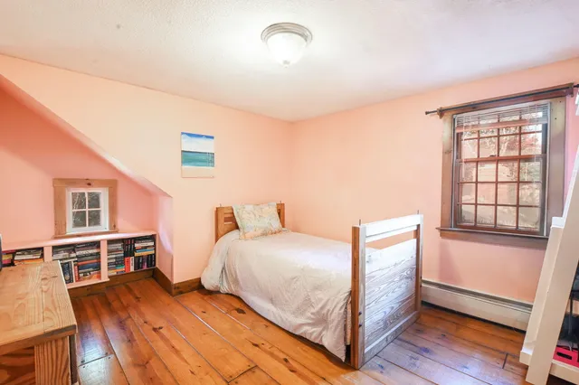 a bedroom with a bed and a wooden floor