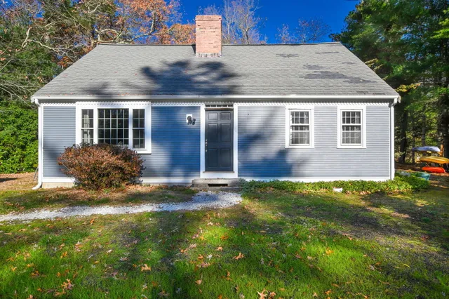 a view of a house with backyard and trees