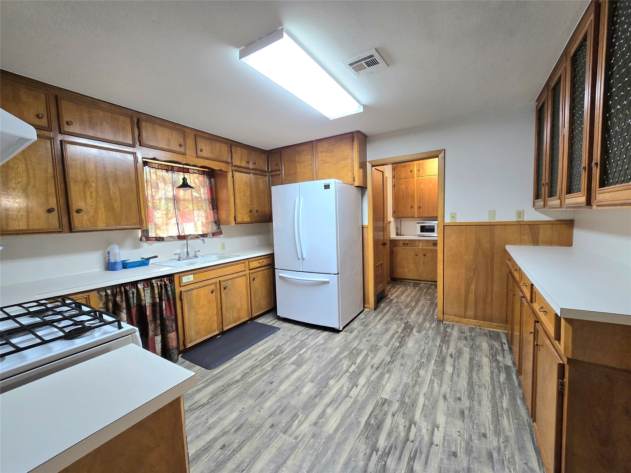 607 South Main Street Dayton, TX 77535 - Photo 11 of 39 a kitchen with wooden floors and wooden cabinets