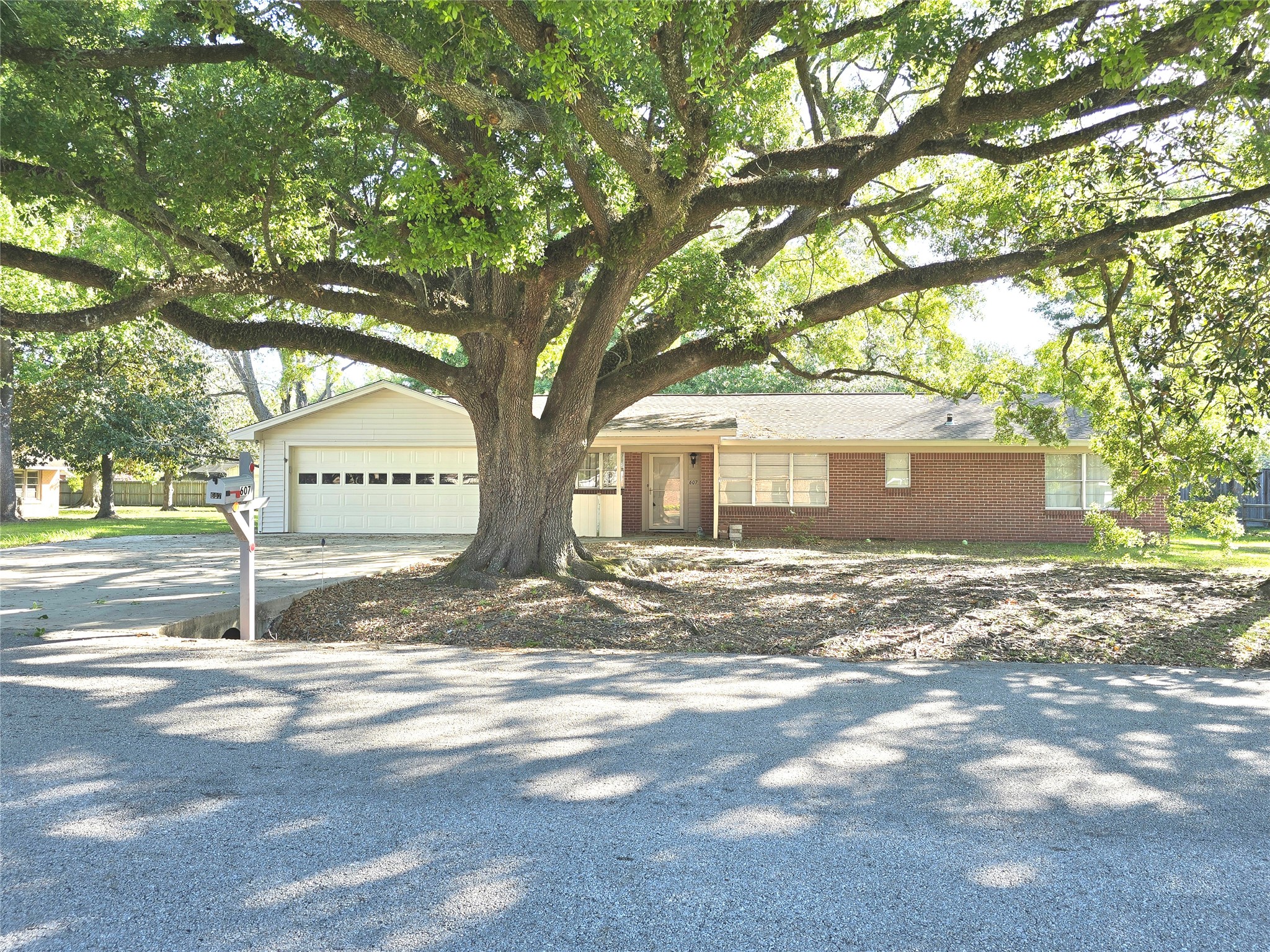 607 South Main Street Dayton, TX 77535 - Photo 2 of 39 a view of a trees in front of a house