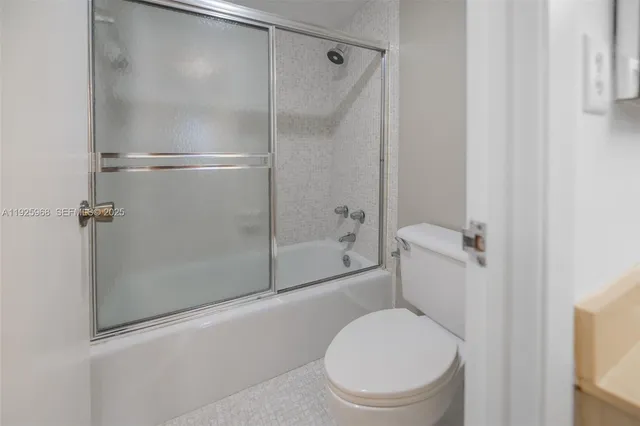 a white toilet sitting next to a bath tub