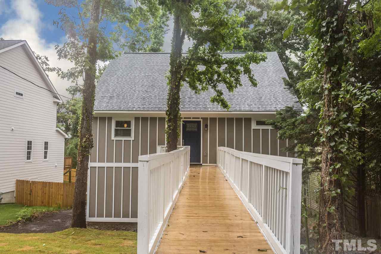 a view of a house with a small yard and wooden fence