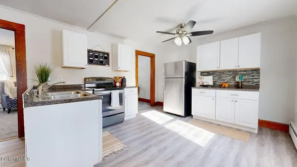 a kitchen with a refrigerator and a stove top oven