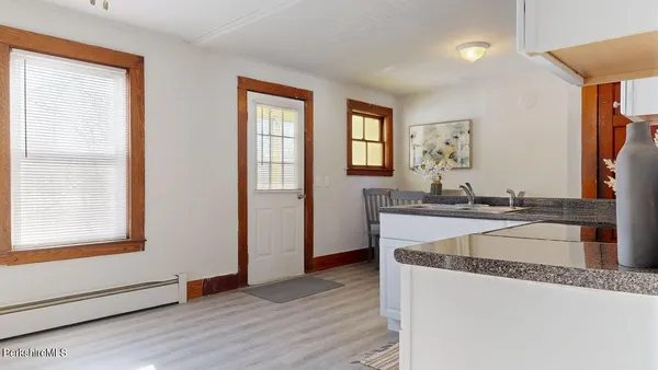 a kitchen with granite countertop a sink and a stove with wooden floor