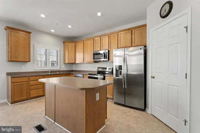 a kitchen with stainless steel appliances granite countertop a refrigerator a stove a sink and a microwave