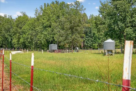 an aerial view of residential houses with outdoor space and trees