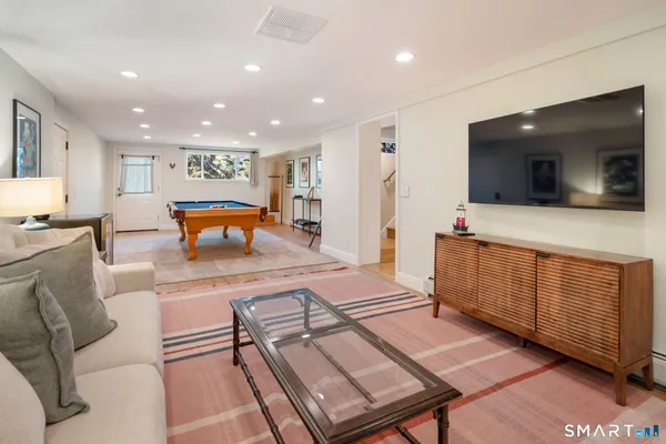 a living room with furniture pool table and glass door