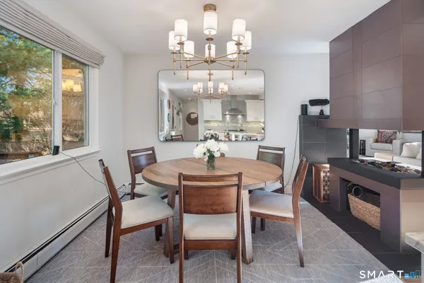 a kitchen with stainless steel appliances a dining table wooden floor and a view of living room