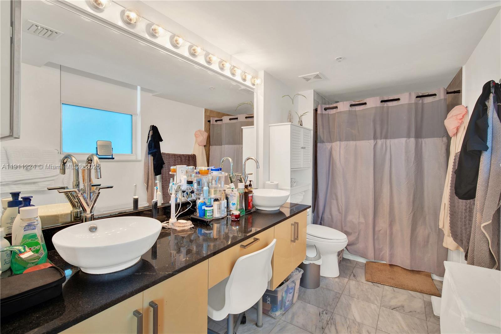 31 Southeast 5th Street, Unit 2910 Miami, FL 33131 - Photo 21 of 34 a bathroom with sink and mirror