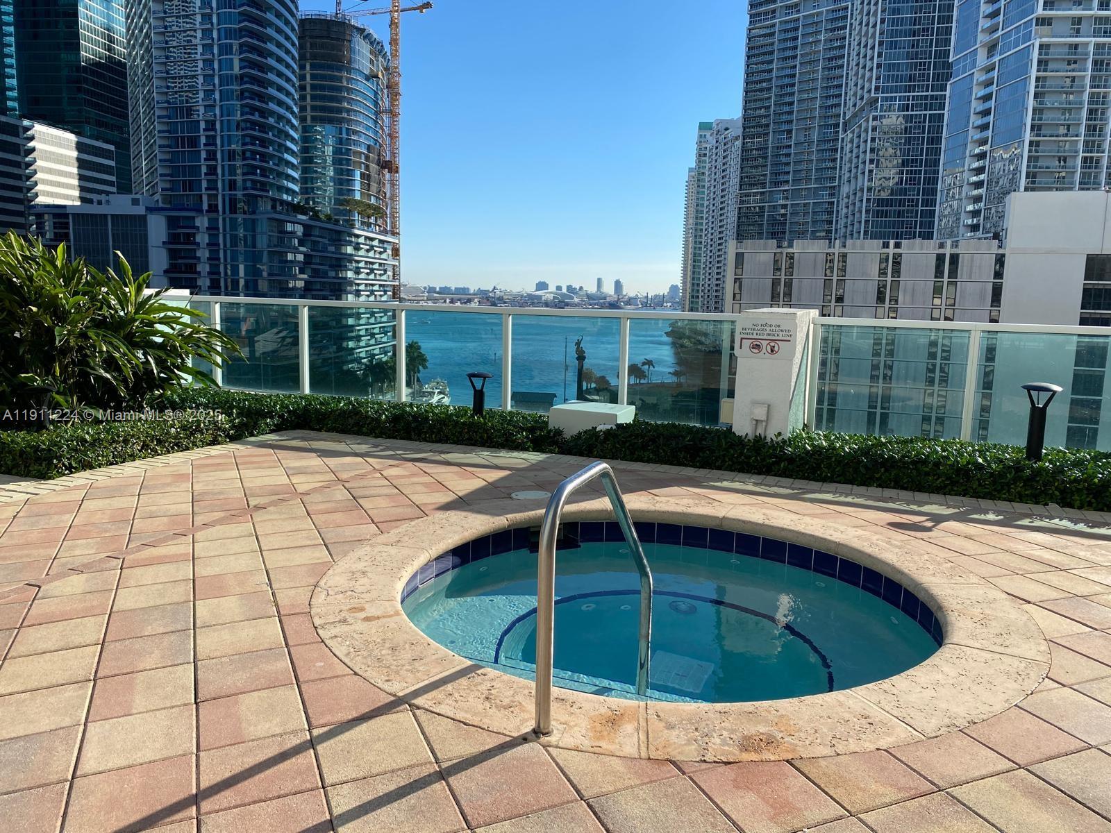 31 Southeast 5th Street, Unit 2910 Miami, FL 33131 - Photo 28 of 34 a view of a swimming pool with a lounge chairs