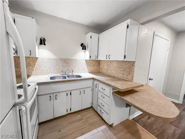 a kitchen with granite countertop a sink stove and cabinets