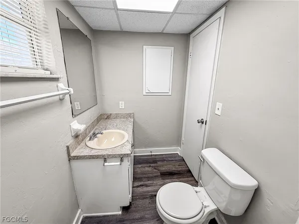 a white toilet sitting next to a bathroom sink and a mirror