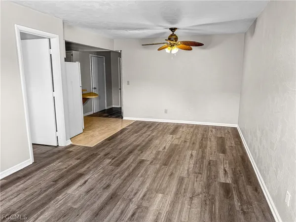 a view of empty room with wooden floor