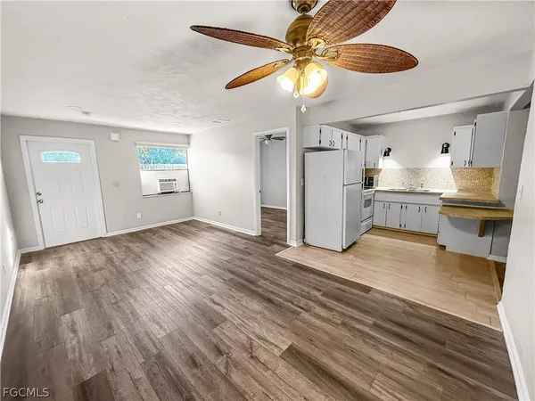 a view of a kitchen with wooden floor and a ceiling fan