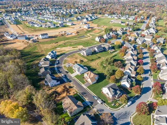 an aerial view of residential houses with outdoor space and swimming pool