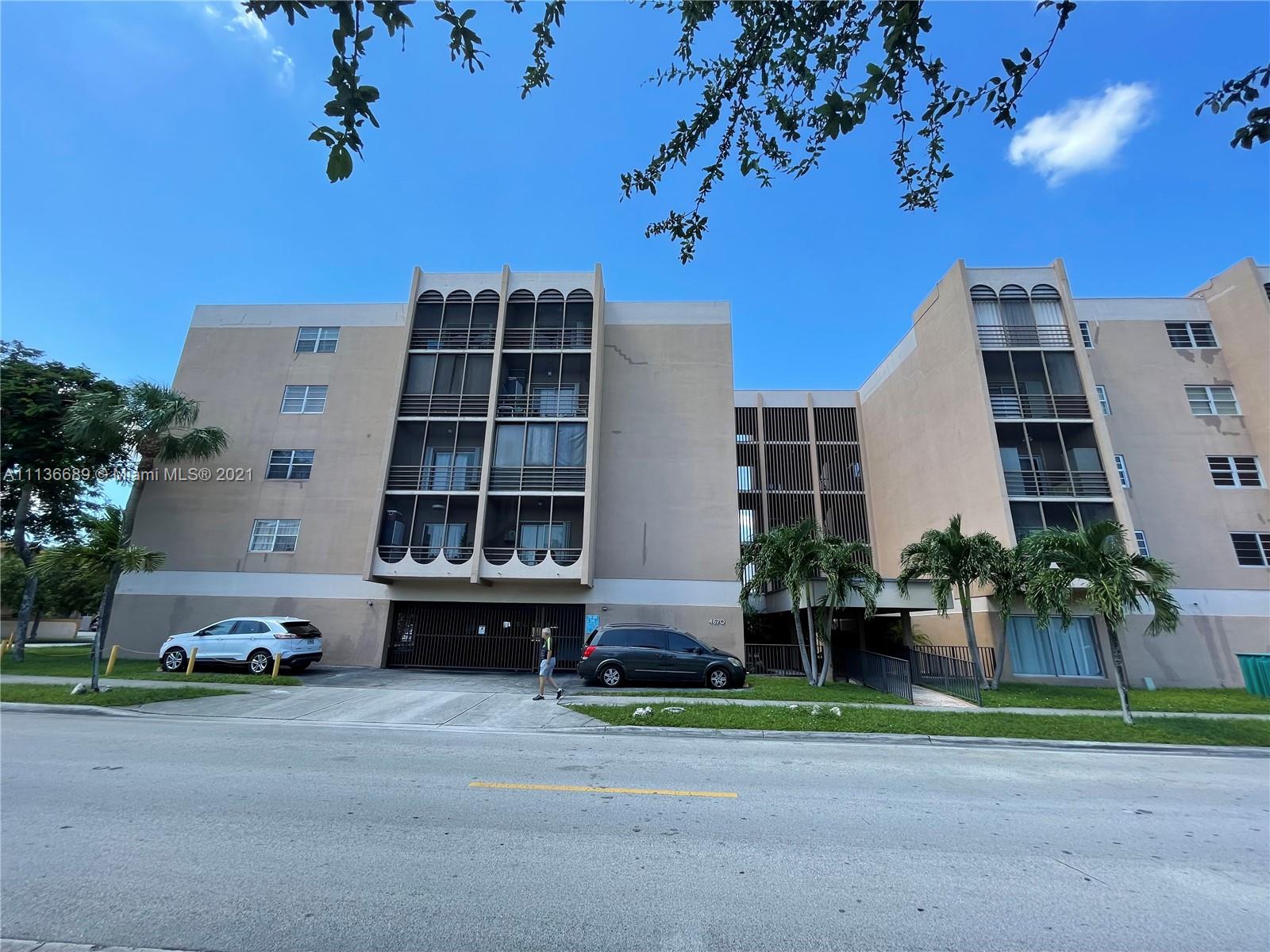 4670 West 13th Lane, Unit 210 Hialeah, FL 33012 - Photo 1 of 11 a front view of a building with garden
