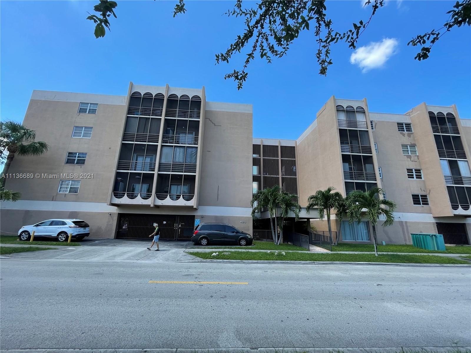 4670 West 13th Lane, Unit 210 Hialeah, FL 33012 - Photo 8 of 11 front view of a building with a yard